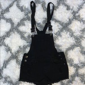 ripped solid black denim overall .